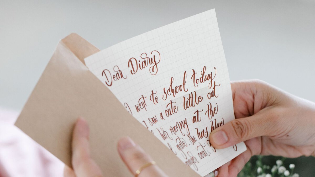 A handwritten letter being taken from an envelope