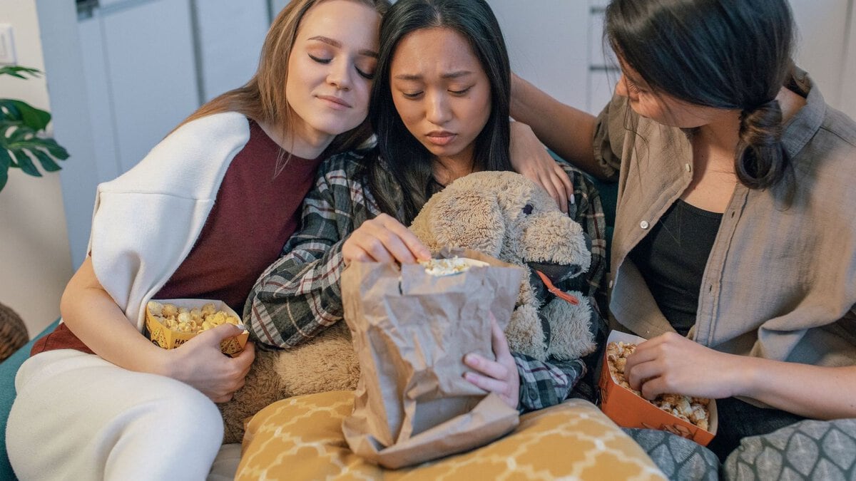 Friends sitting beside and comforting a woman