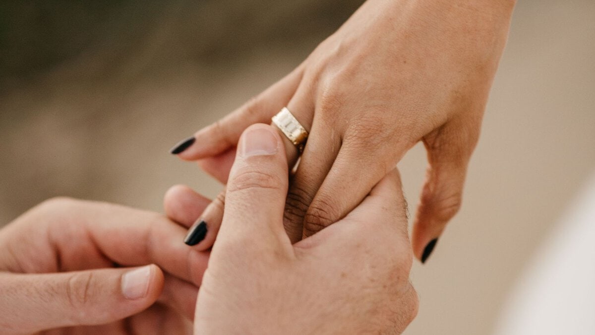 Close-up of a ring being placed on a hand.