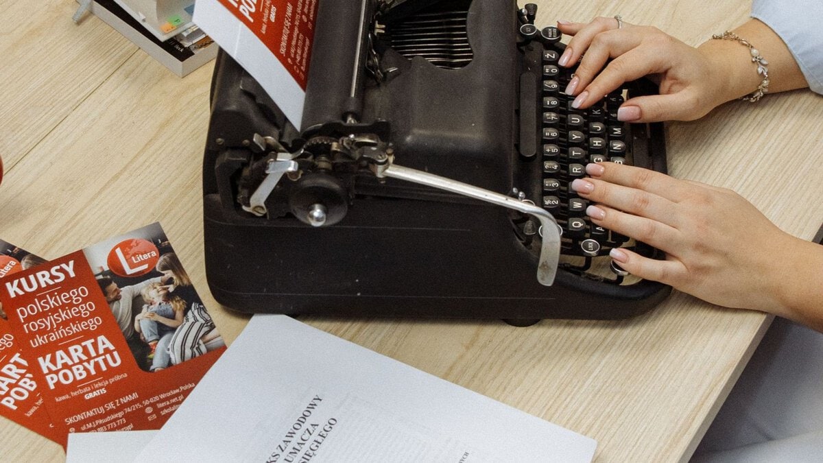 Hands typing on a vintage typewriter
