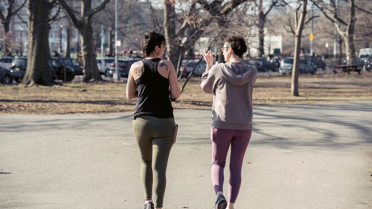 Two women walking and talking in a park