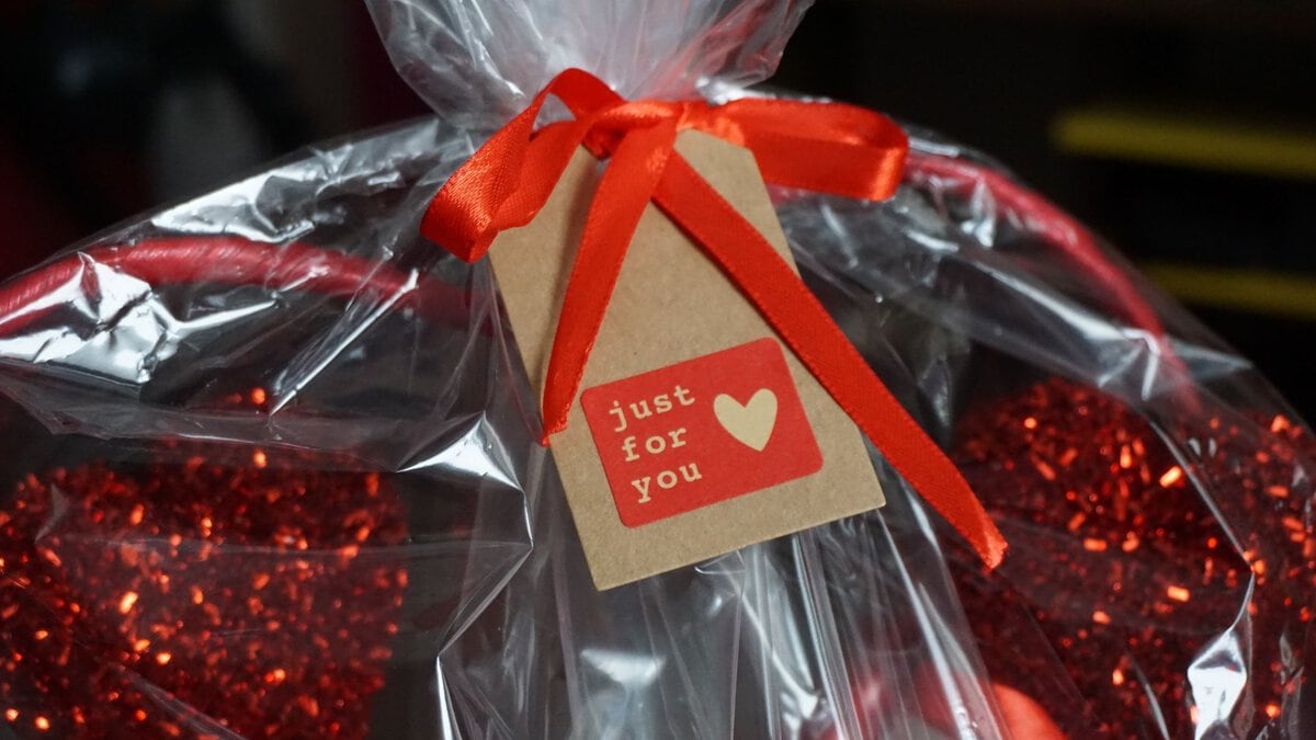 A wrapped gift basket with a red ribbon