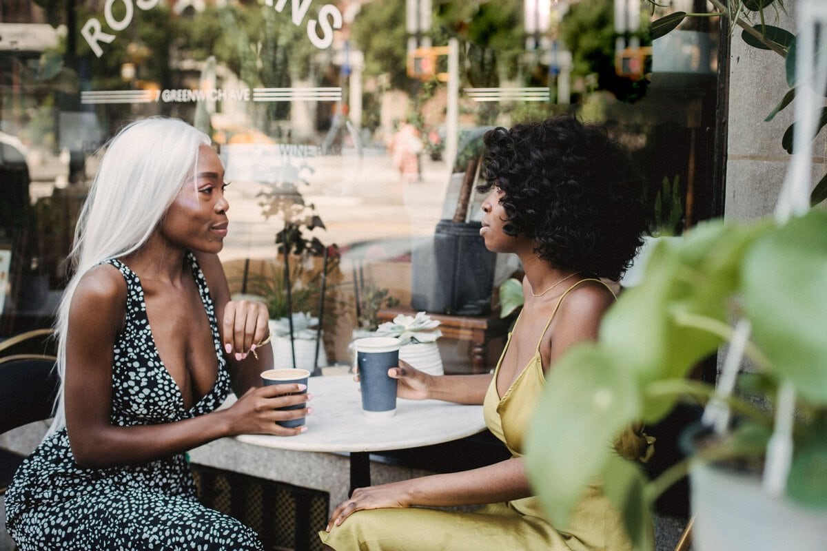 Two friends talking outside a cafe
