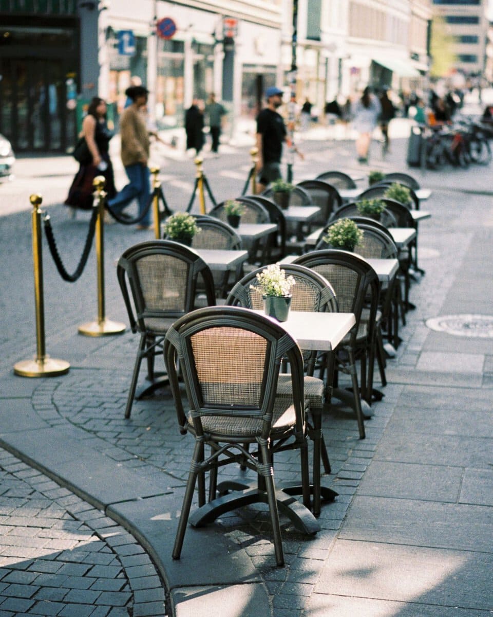 Empty outdoor cafe seating on a cobbled street