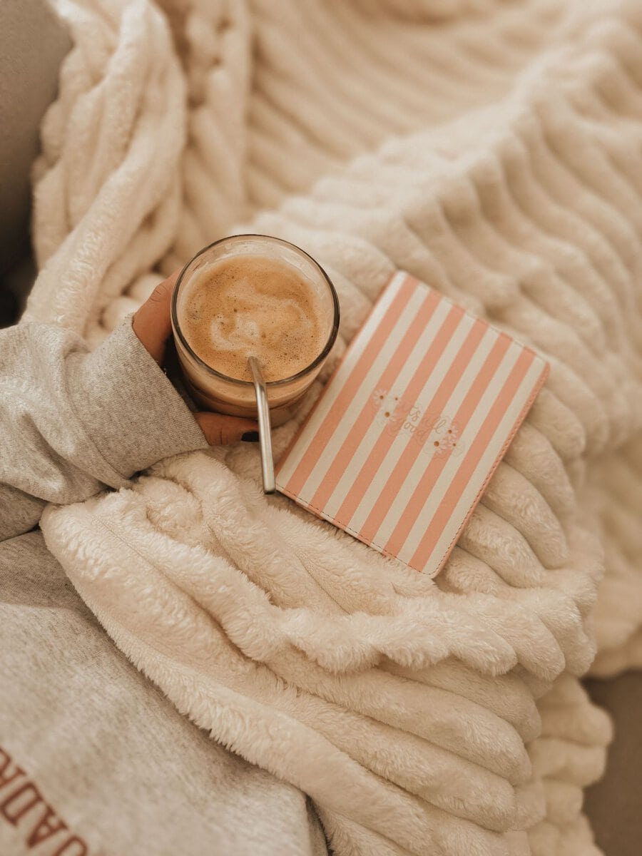 Coffee and a journal on a soft blanket