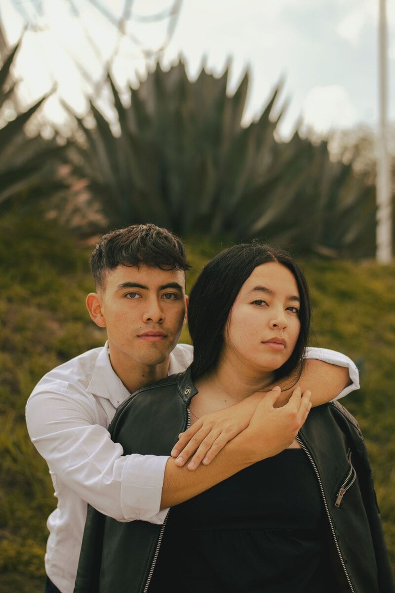 Couple standing together among green plants