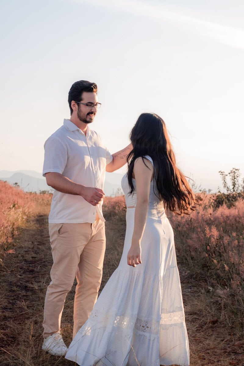 Couple walking through a field in warm evening light