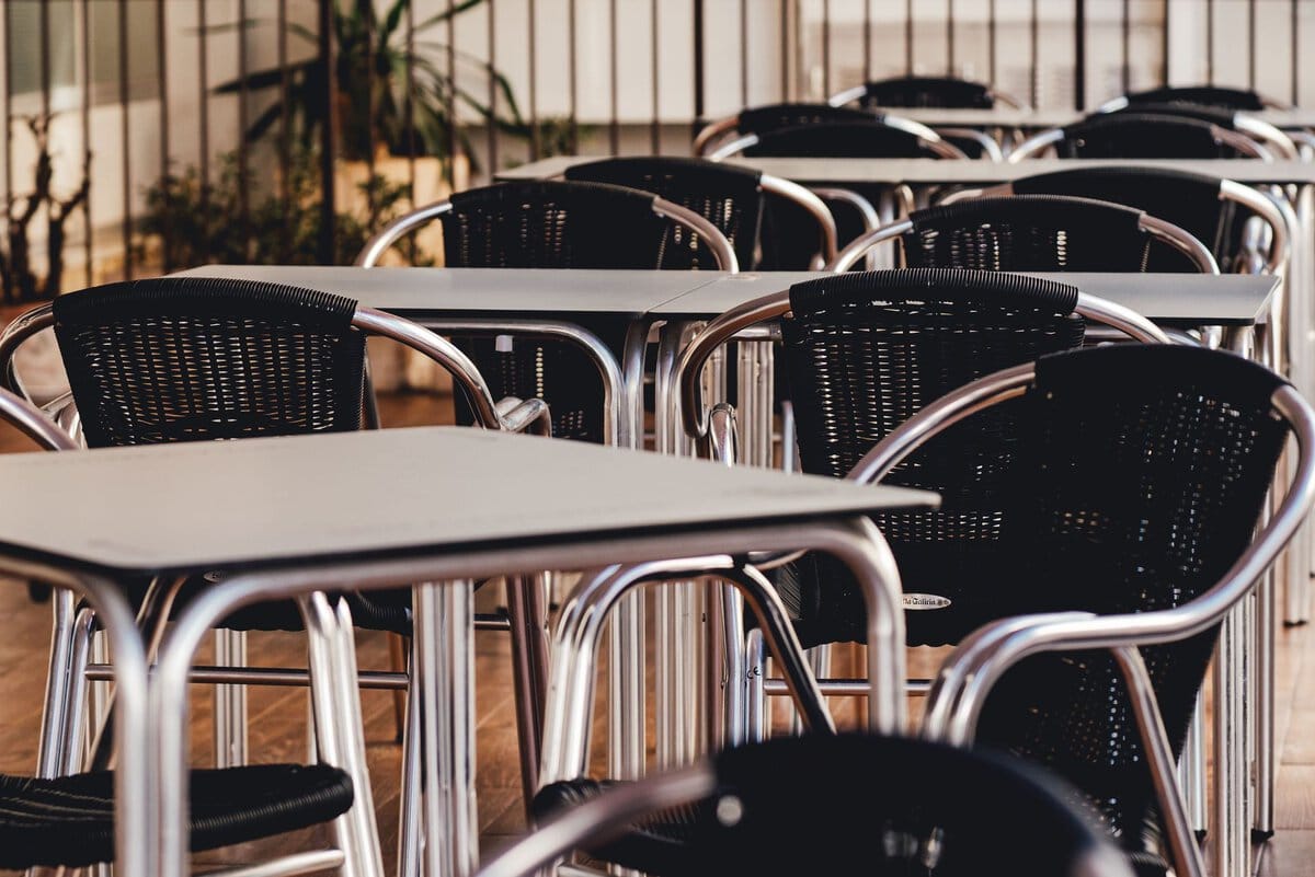 Empty tables and chairs on an outdoor cafe terrace
