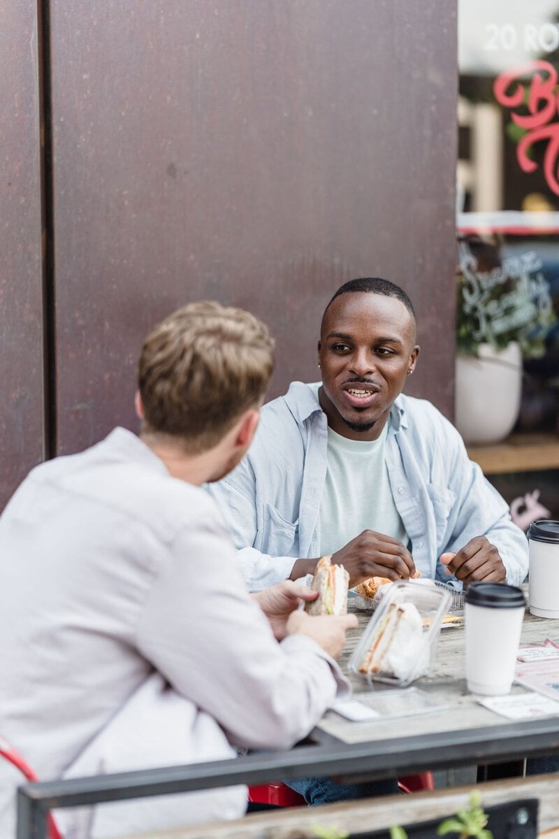 Two friends talking over lunch outdoors