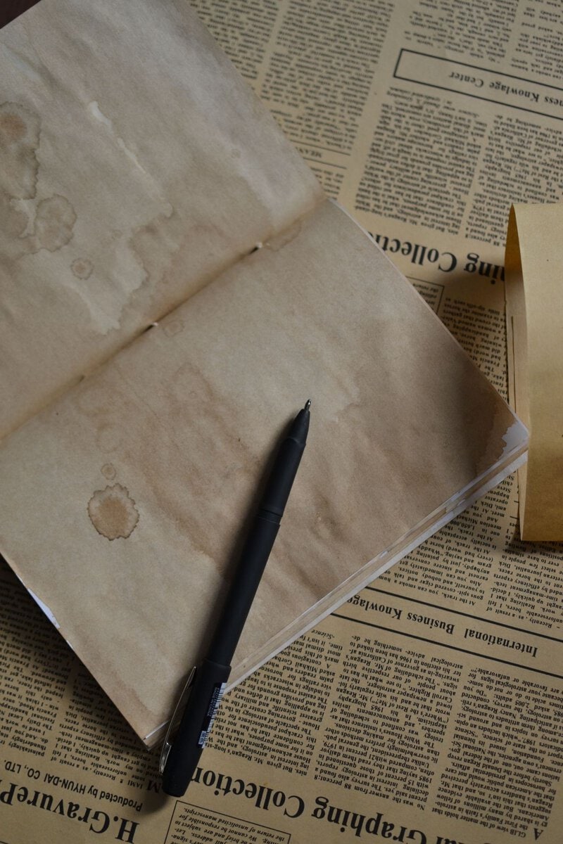 Open notebook with a pen on newspaper pages