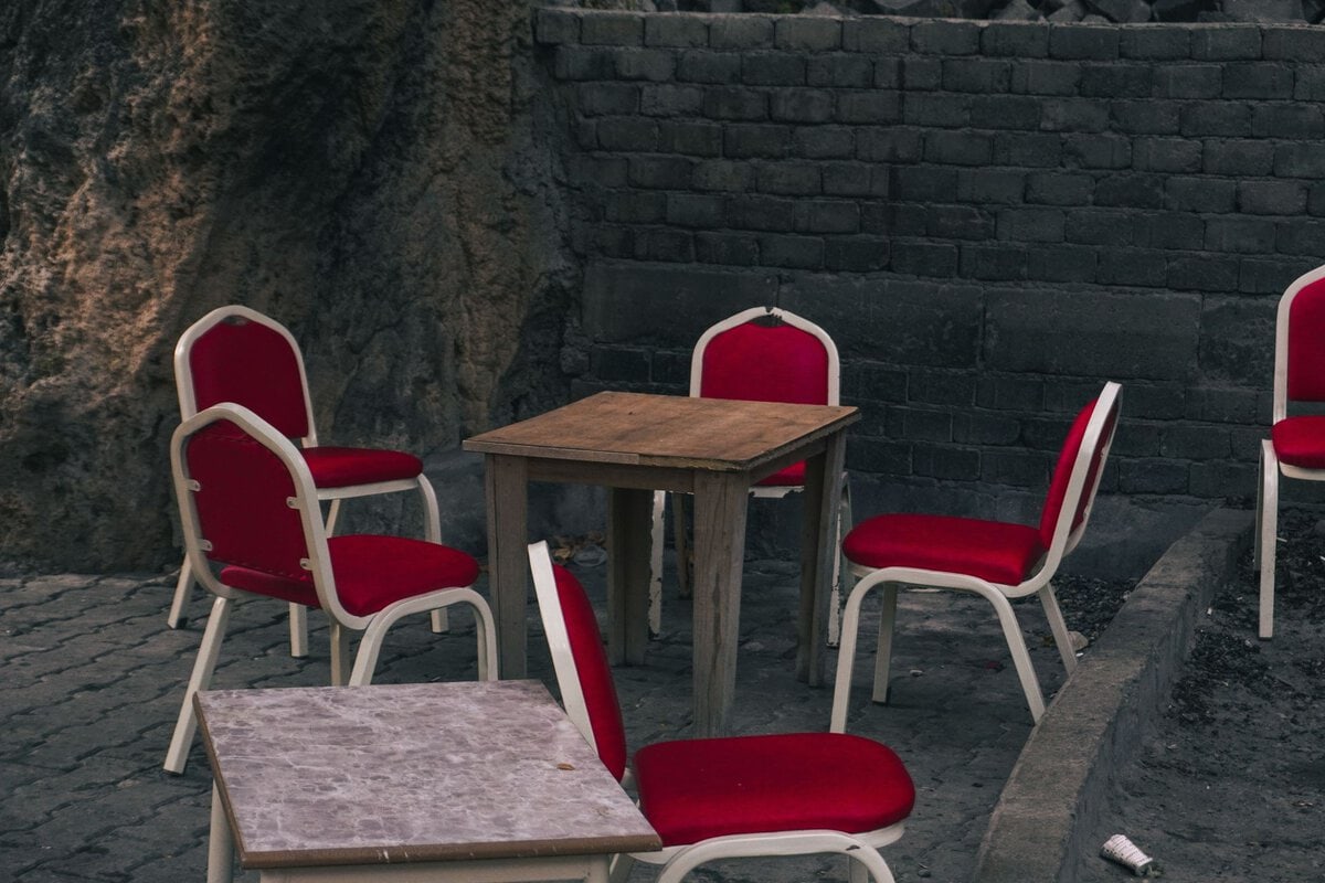 Empty red chairs around a courtyard table