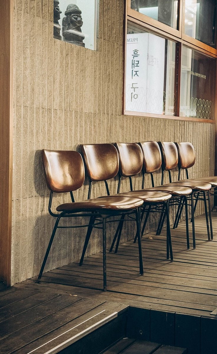 Empty chairs lined up outside a cafe