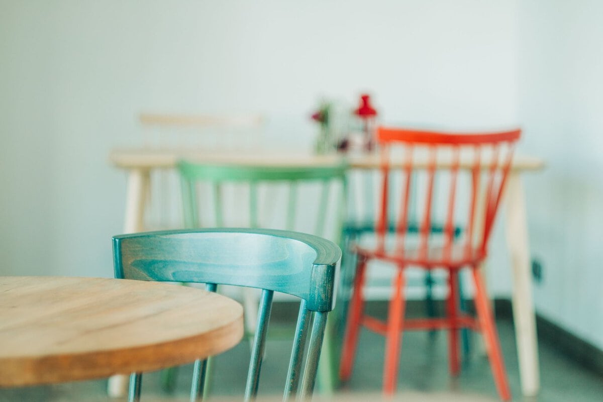 Colorful wooden chairs around cafe tables