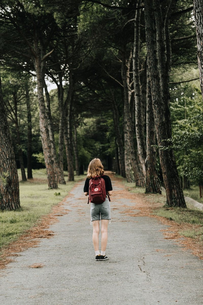 A walker with a backpack on a forest path
