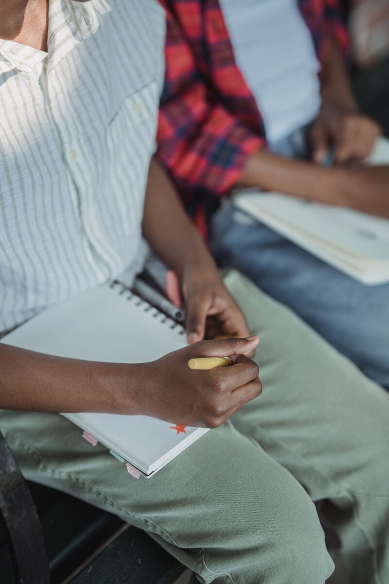 Hands holding a notebook and pencil