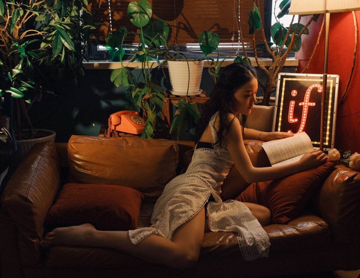 Woman reading a book on a sofa
