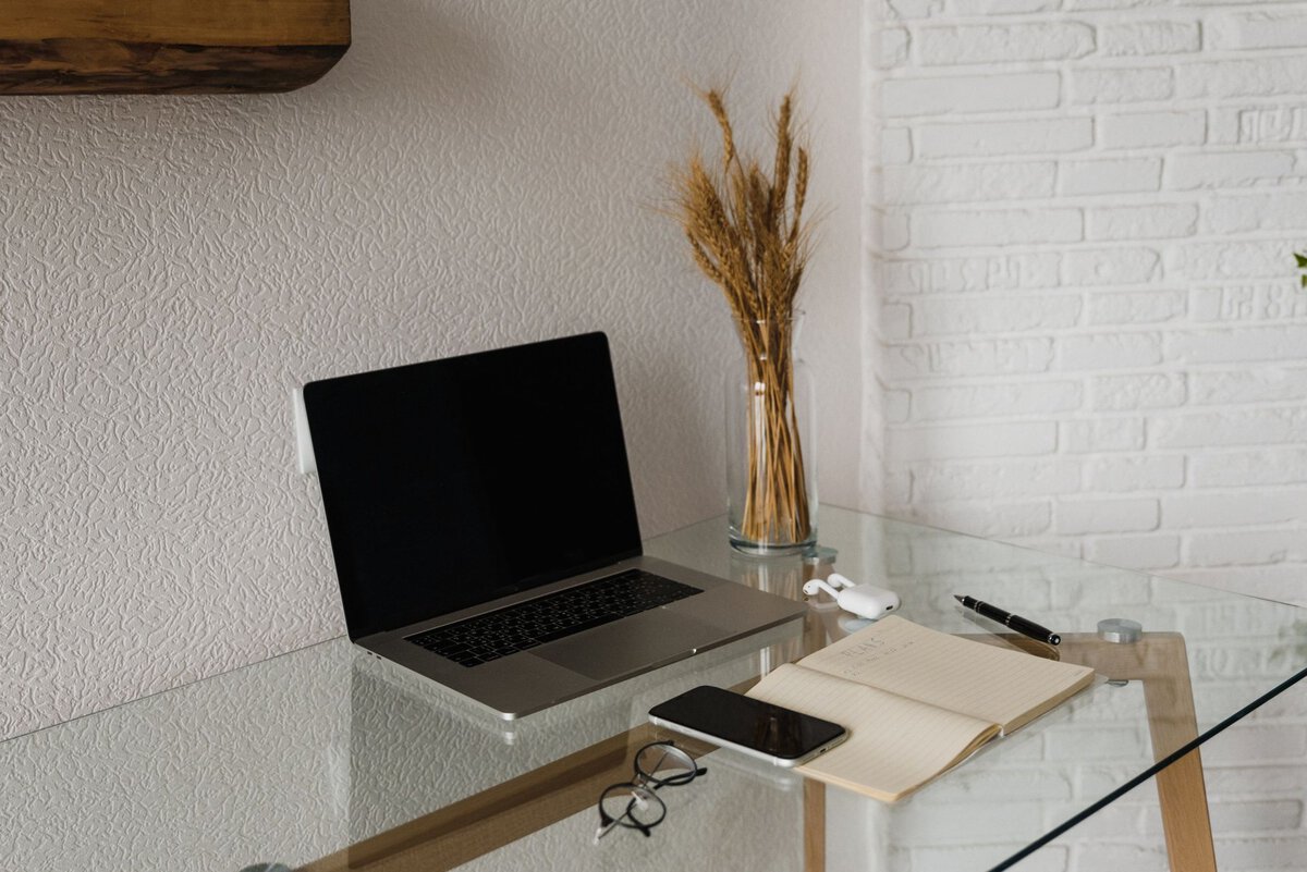 Laptop and notebook on a glass desk